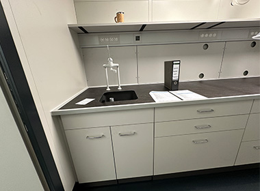 Laborarbeitsbereich mit Arbeitsplatten in „Betonoptik“ und passendem Becken